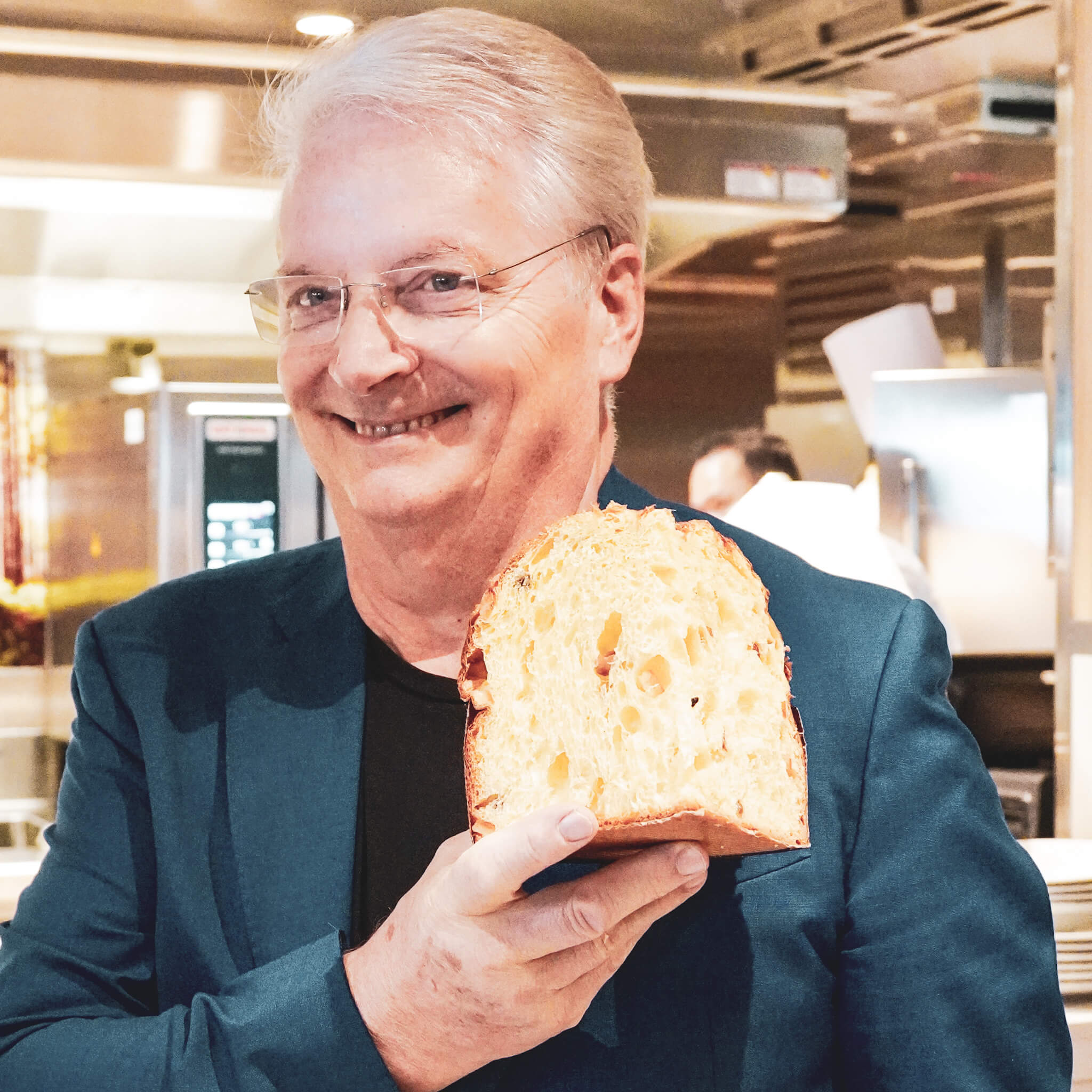 "Panettone senza Confini" an Bord der Costa Smeralda: Meisterbäcker Iginio Massari hält ein Stück  Panettone