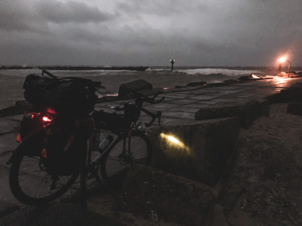 bepacktes Fahrrad im Dunkeln am Meer