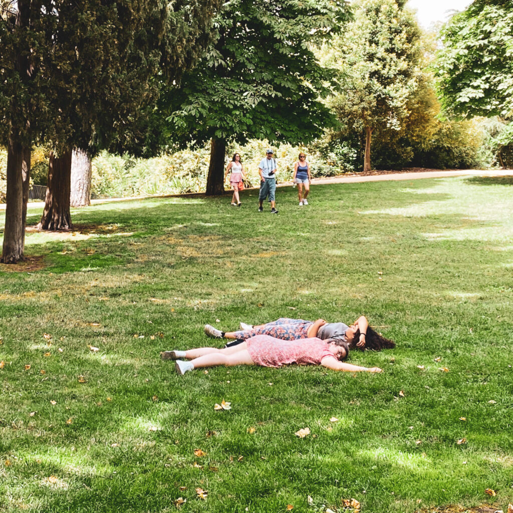 Menschen liegen auf einer Wiese im Retiro Park Madrid