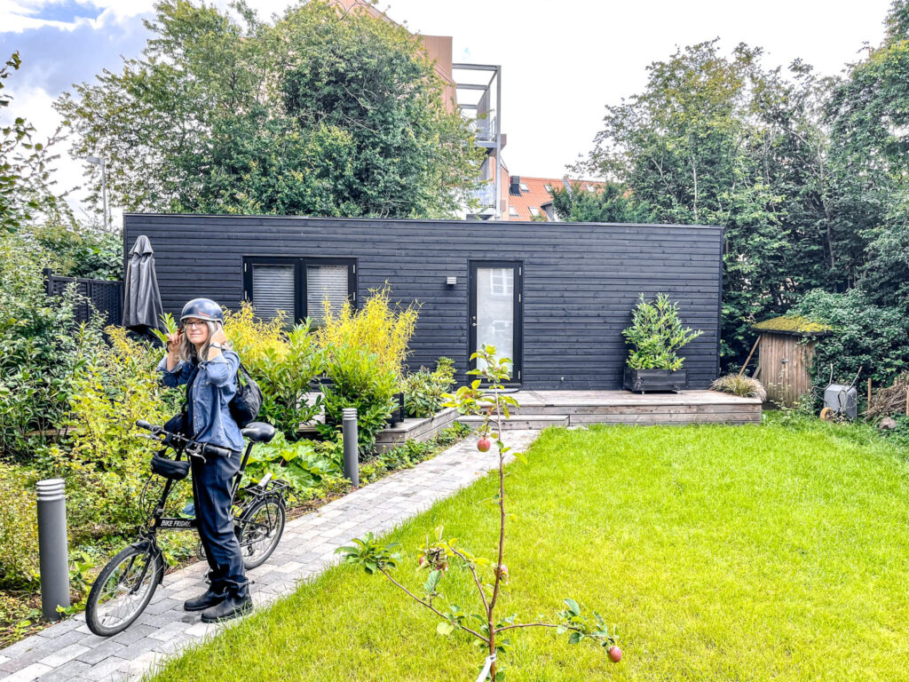 Freundin von Welt mit Faltrad vor dem Airbnb Tiny House in Aarhus