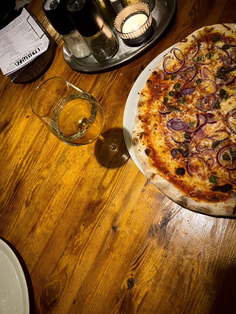 Pizza und Wein auf dem Tisch in der Pizza Band