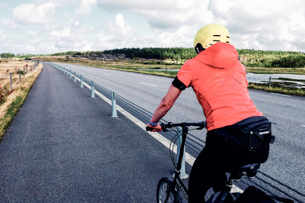 Kattegattleden Schweden: Frau fährt mit dem Rad auf Fahrradstreifen neben der Straße