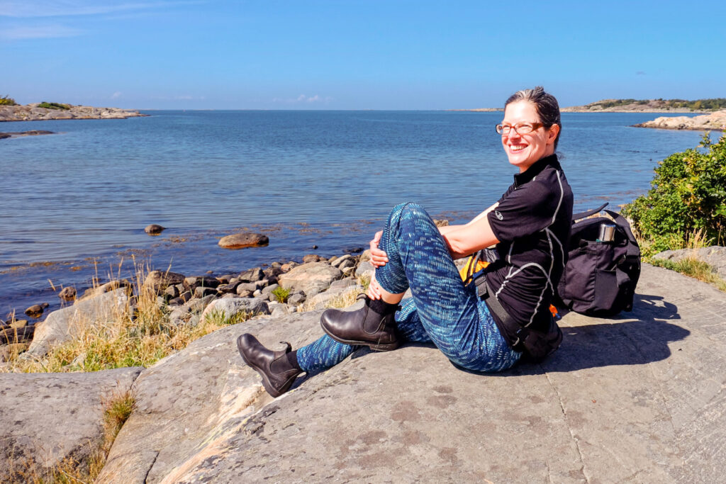Freundin von Welt auf Radreise auf dem Kattegattleden in Schweden, Pause am Meer auf einem Felsen