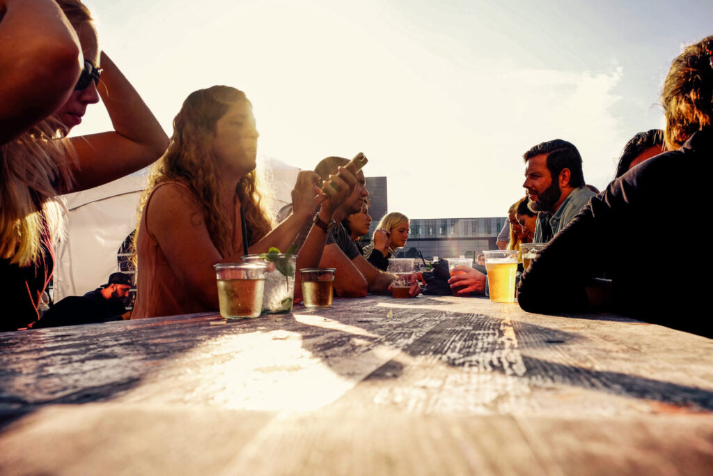 Menschen am Tisch mit Drinks beim Streefood in Kopenhagen