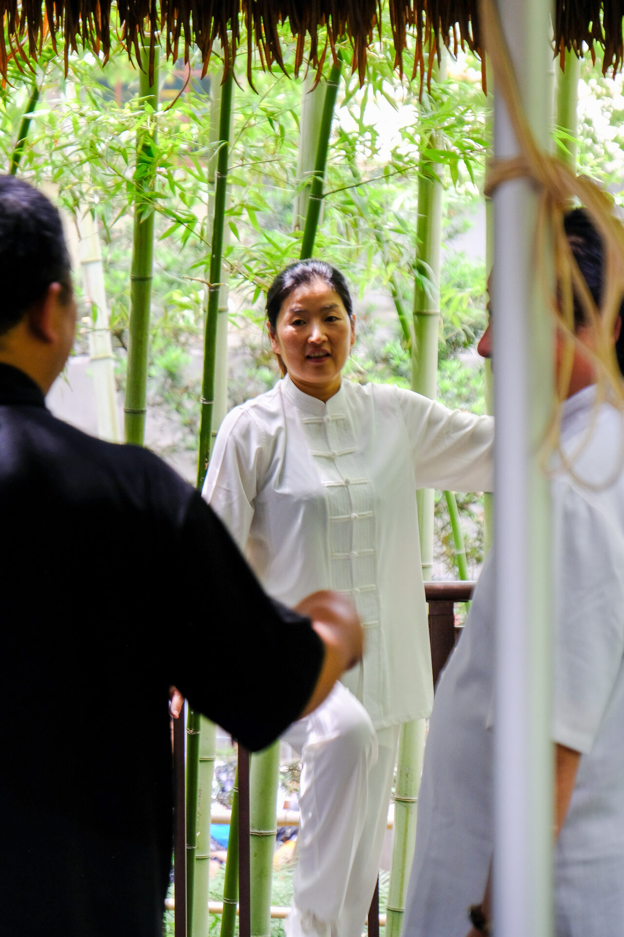 Frau im weißen Anzug macht Taijiquan im Park in Shanghai