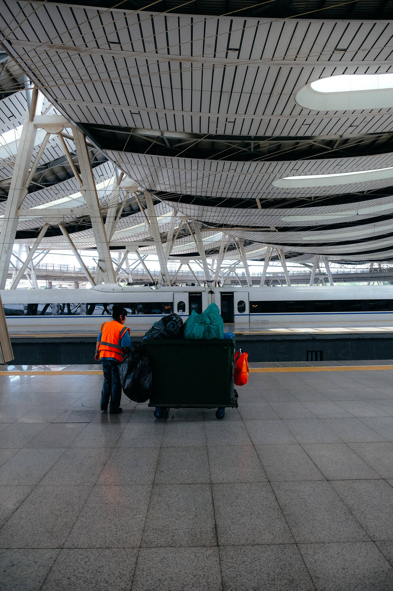 Müllarbeiterin auf dem Bahnsteig, Südbahnhof Beijing