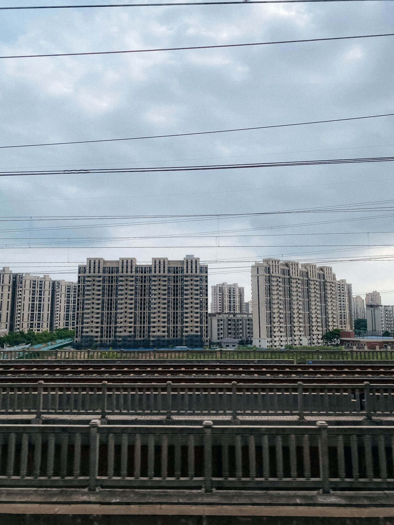 Blick aus dem Zug in China auf Hochhäuser