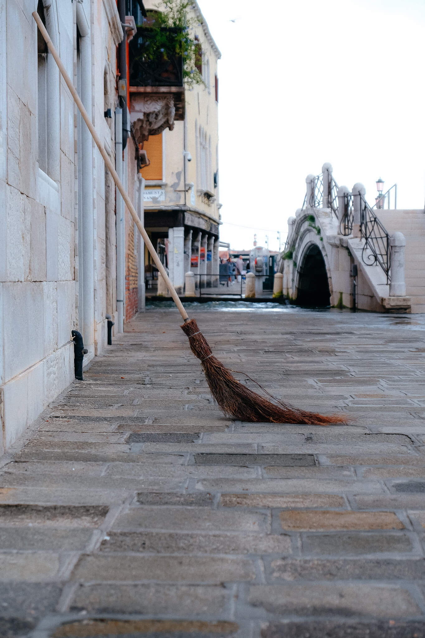 ein Besen lehnt an der Wand auf der Promenade in Venedig