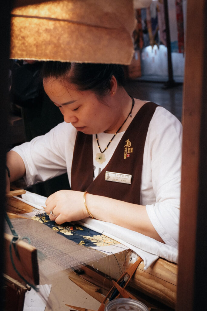 China, Wuzhen: Brokatweberin bei der Arbeit