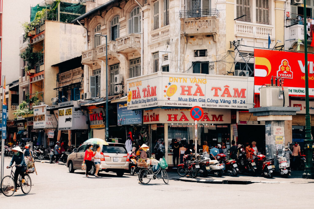 Straßenszene in Saigon: Kolonialarchitektur, Motorroller, Fahrräder – alles dabei