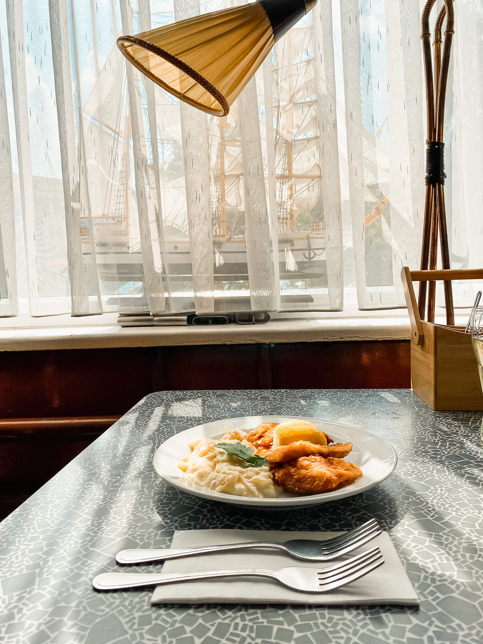 auf dem Resopaltisch der Veddeler Fischgaststätte steht ein Teller mit Backfisch und Kartoffelsalat