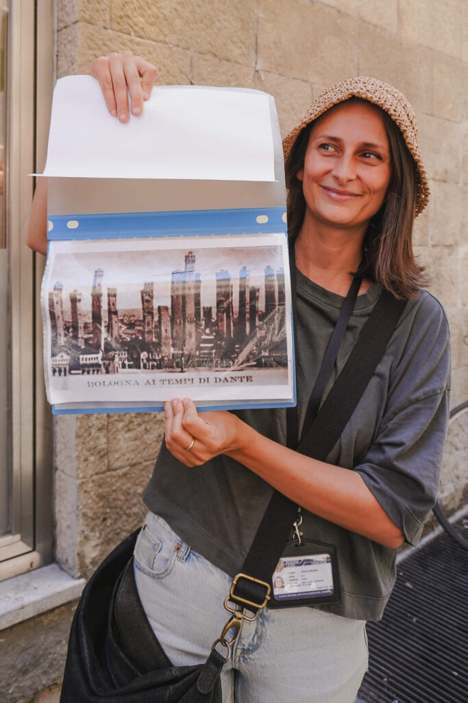 Guide Ela zeigt ein Bild von Bologna zu Dantes Zeiten